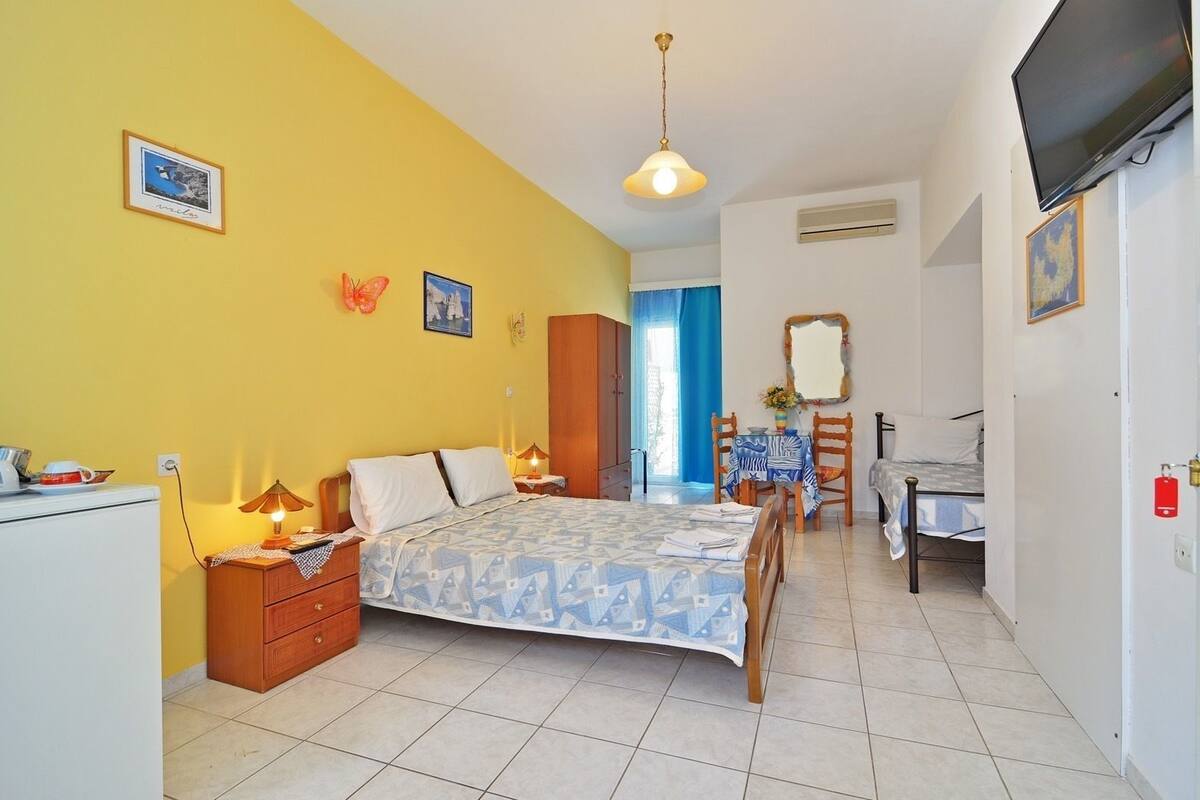 Um quarto com uma cama, mesas de cabeceira, uma escrivaninha e uma cadeira.