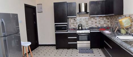 Penthouse, Multiple Beds, Non Smoking | Private kitchen | Full-size fridge, microwave, oven, stovetop