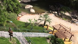 A landscaped area with a paved walkway, a small pool, and a wooden pergola. - Pousada Alpenhof (Sao Pedro de Alcantara)
