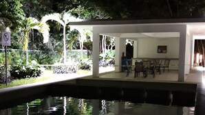 A room with a bed, a desk, and a window overlooking a garden. - Casa Falabella - Puerto Marino (Puerto Morelos)
