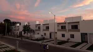 A modern building with a flat roof, rectangular windows, and a white facade. - Casa Falabella - Puerto Marino (Puerto Morelos)