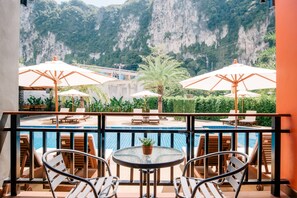 A balcony with a pool, chairs, and umbrellas, overlooking a mountainous landscape. - Frank Ao Nang Krabi Resort (Krabi)