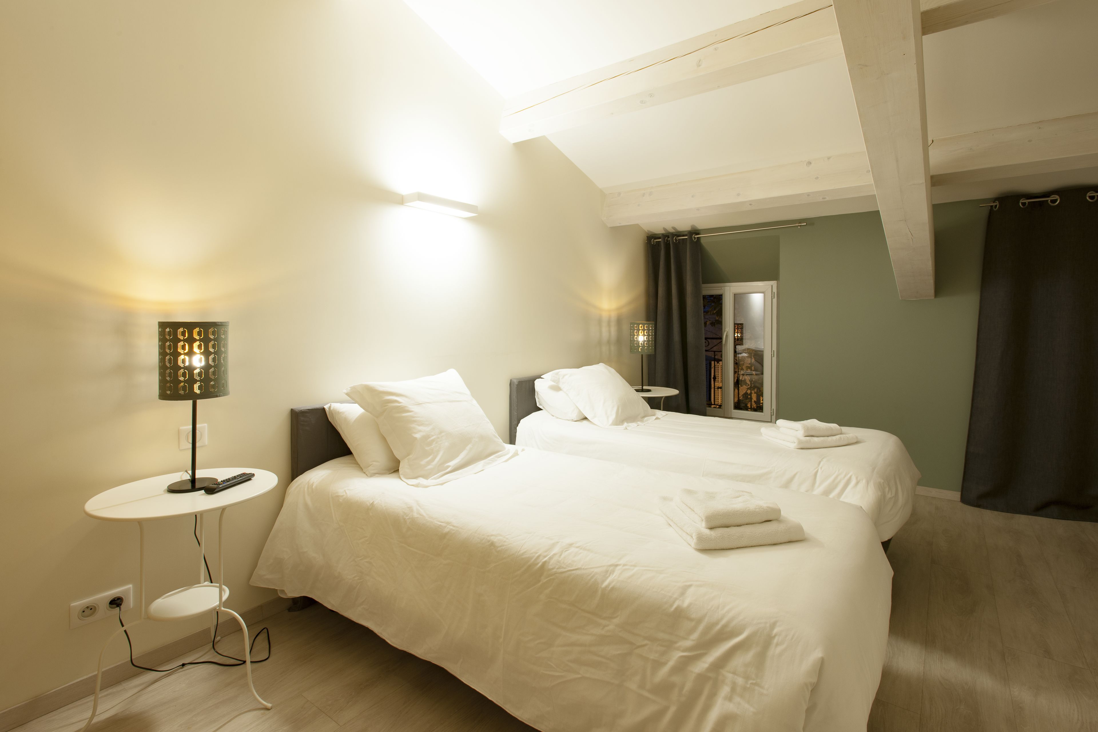 Een slaapkamer met een groot bed, nachtkastjes en een lamp.