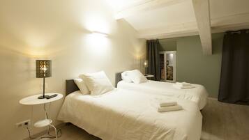 A bedroom with a large bed, bedside tables, and a lamp.