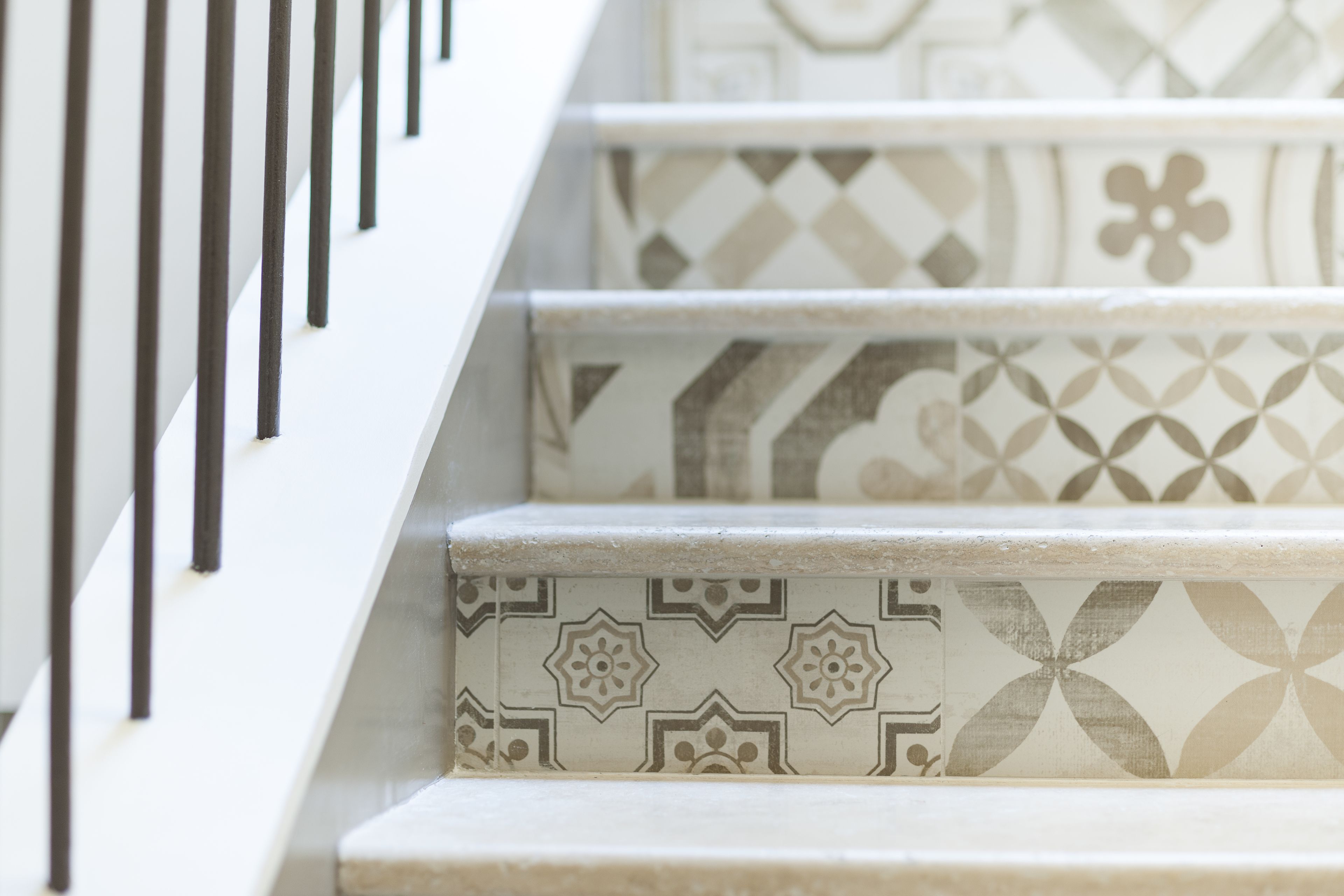 A staircase with patterned tiles and a metal railing.