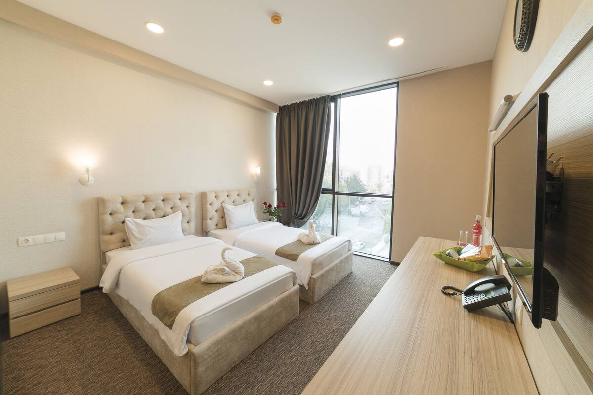 Standard Twin Room | Minibar, in-room safe, desk, iron/ironing board