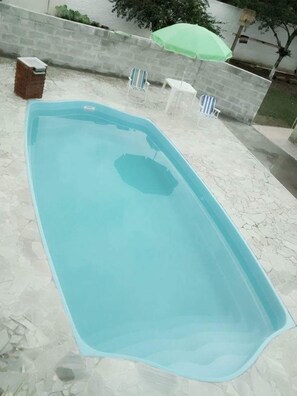 Una piscina rectangular con solárium alicatado.