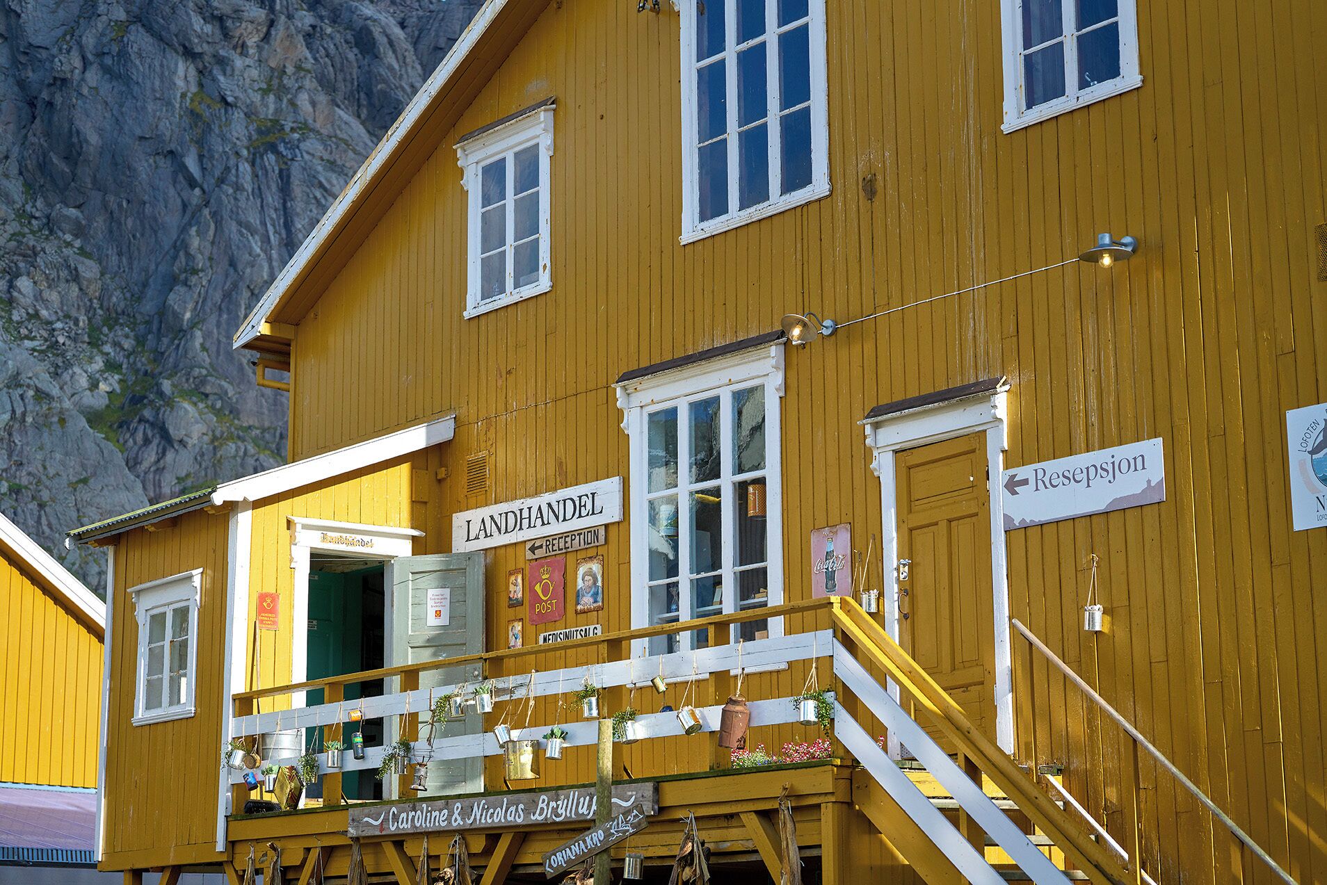 A yellow building with a sign for 'Landhandel' and 'Rezeption' indicating a reception area.