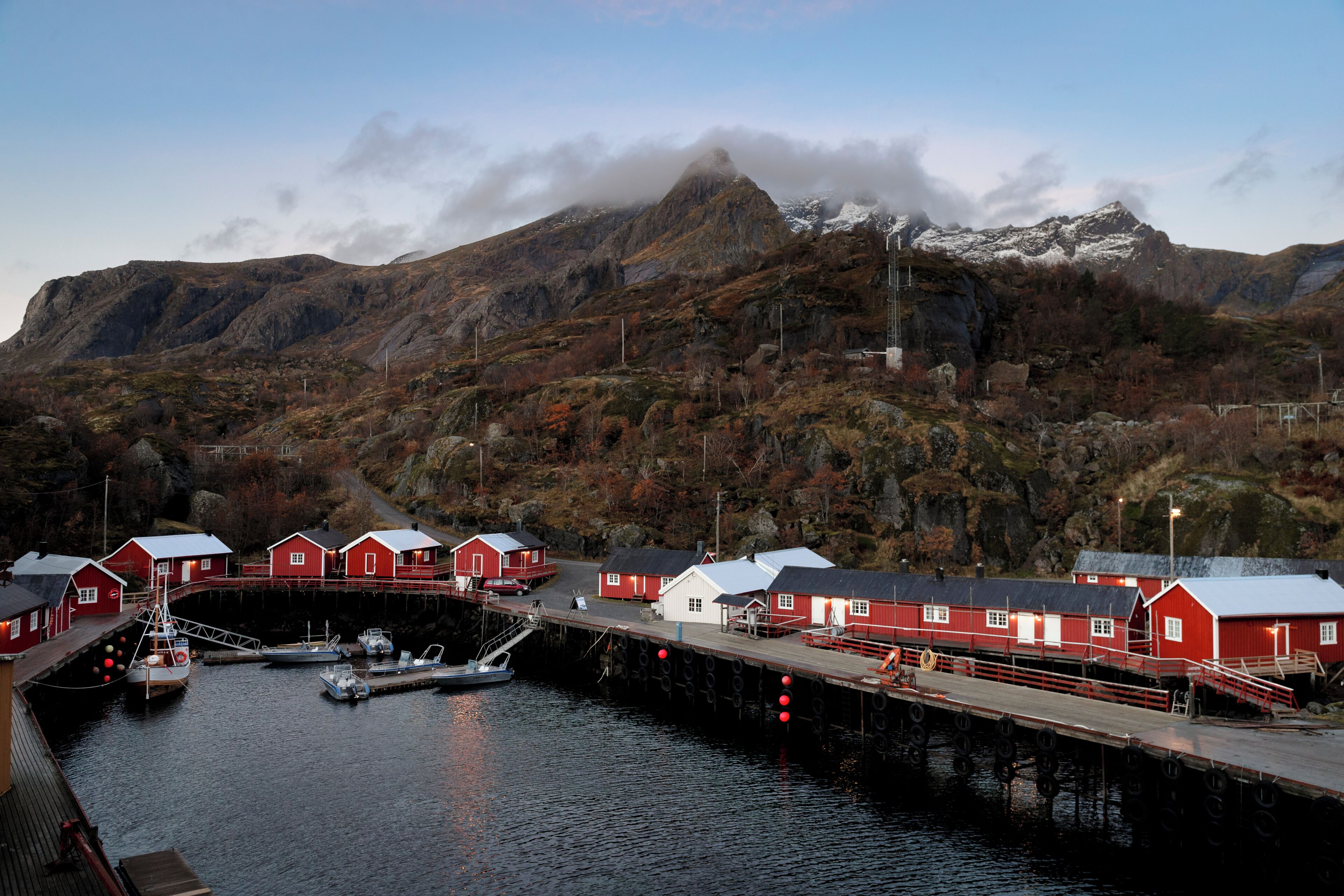 Un village côtier avec des bâtiments rouges, un quai et des bateaux.