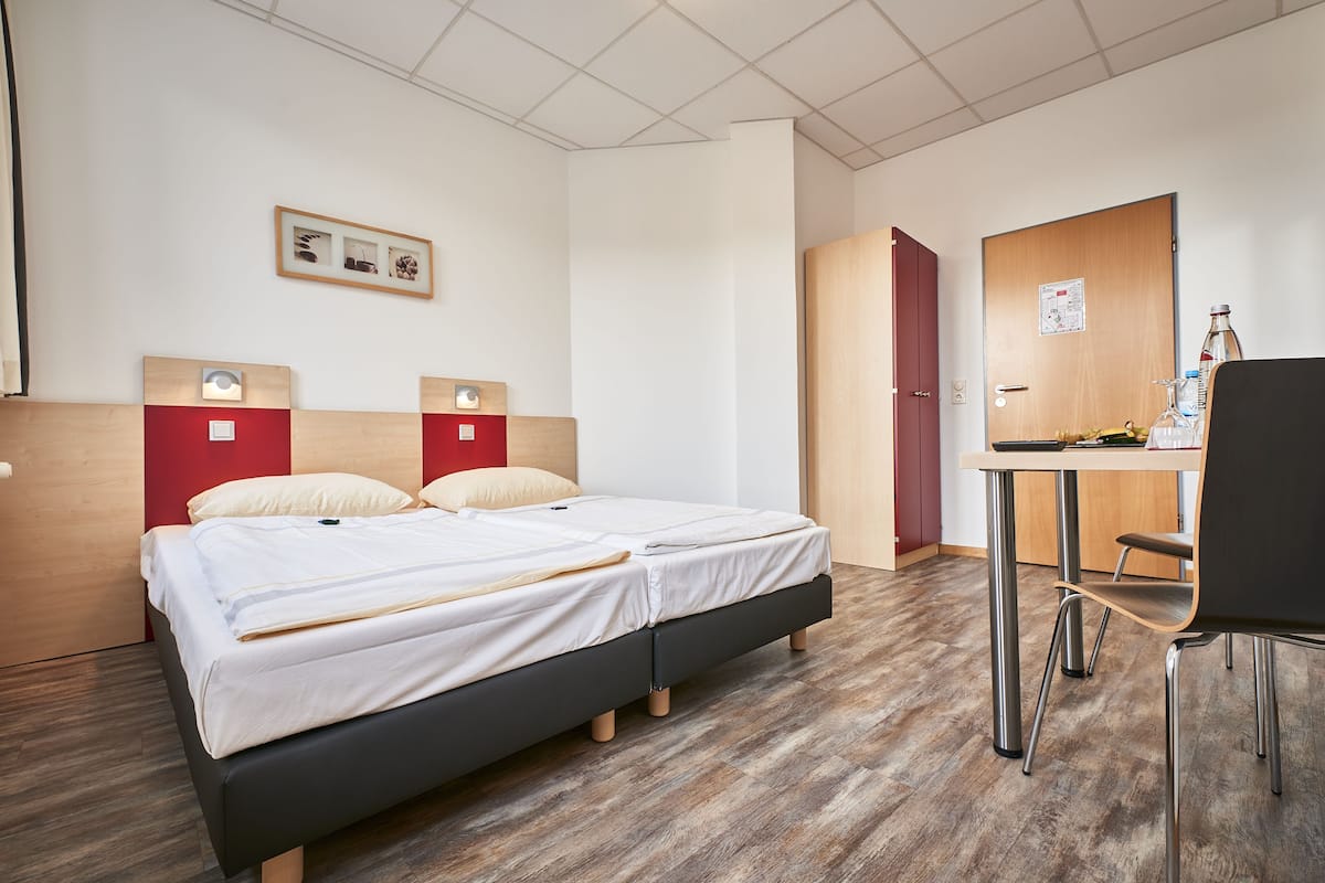 Una habitación de hotel moderna con dos camas, un escritorio y una silla.