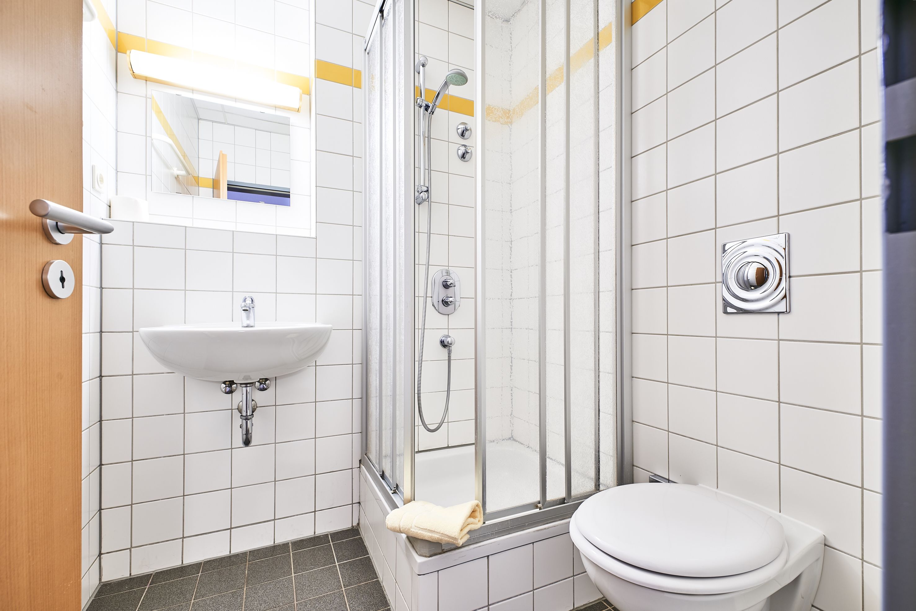 A bathroom with a white sink, a toilet, and a glass-enclosed shower.