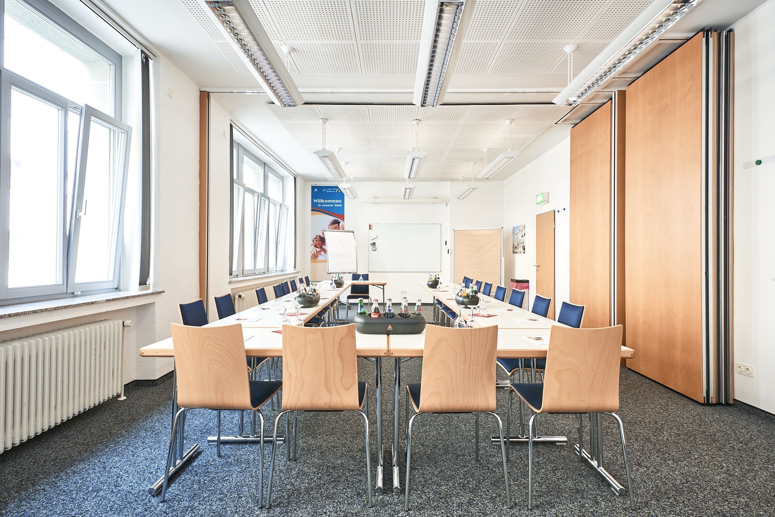 A conference room with a long table, four chairs, and a whiteboard.