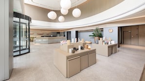 A spacious lobby with a reception desk, a large potted plant, and a modern ceiling design. - Ji Hotel (Suzhou)