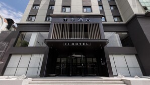 A modern hotel entrance with a prominent sign, a set of steps leading up to the entrance, and a glass facade. - Ji Hotel (Suzhou)