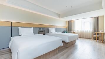 A hotel room with two beds, a desk, and a chair.