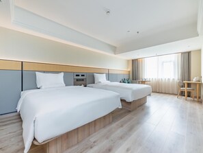 Quarto de hotel com duas camas, uma escrivaninha e uma cadeira.