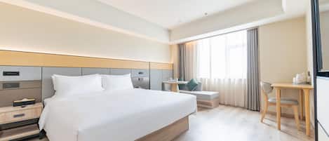 Una habitación de hotel con una cama grande, mesita de noche, escritorio, silla y televisor.