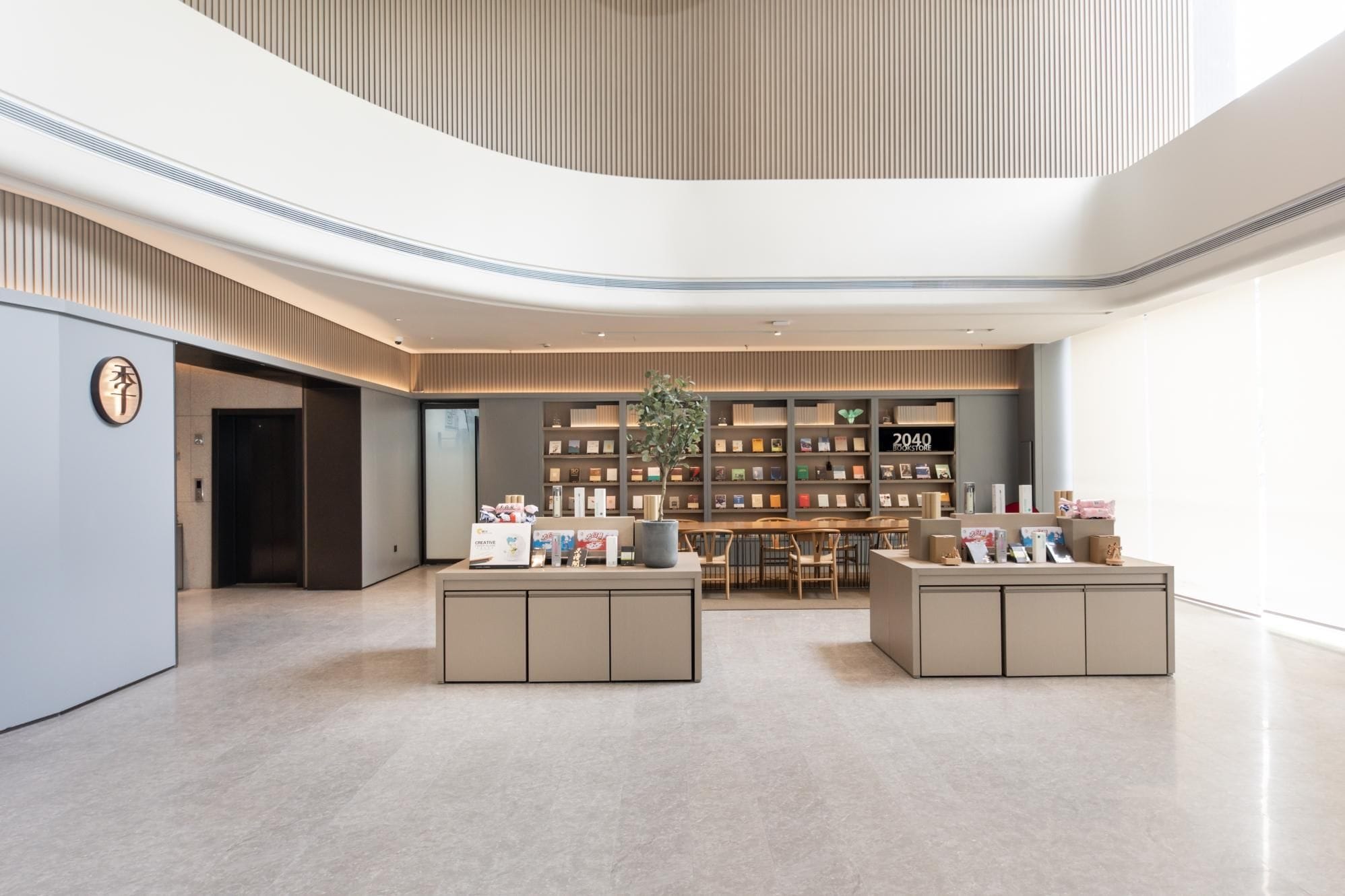 A modern interior with a central seating area, a bookshelf, and a sign reading '2040 BOOKSTORE'.