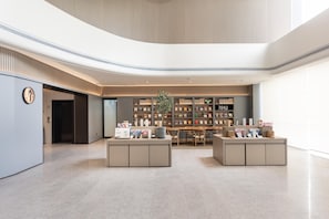 A modern interior with a central seating area, a bookshelf, and a sign reading '2040 BOOKSTORE'.