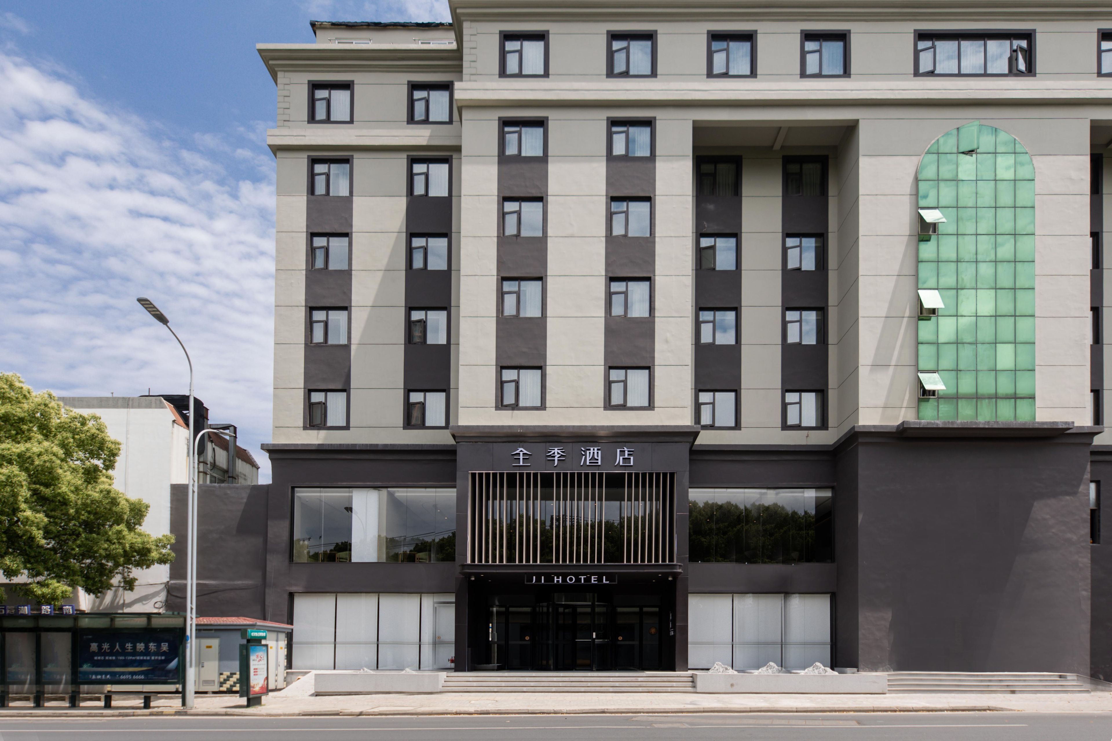 A modern hotel with a symmetrical facade, large windows, and a prominent entrance.