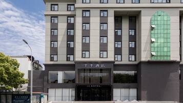 Un hotel moderno con fachada simétrica, amplias ventanas y una entrada destacada.