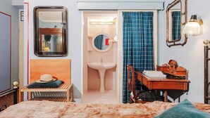 A bedroom with a bed, a desk with a chair, a mirror, a sink, and a window with curtains. - Hotel la Felicina Mugello (Scarperia e San Piero)