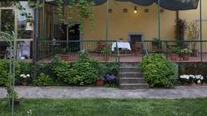A yellow building with a brick tower, a covered patio with tables and chairs, and potted plants. - Hotel la Felicina Mugello (Scarperia e San Piero)