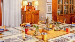 A dining area with a table set for four, featuring a decorative centerpiece, a wooden cabinet with glass doors, and a comfortable seating arrangement. - Hotel la Felicina Mugello (Scarperia e San Piero)