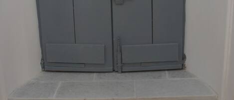 Una puerta metálica gris con un pestillo y un pequeño candado.