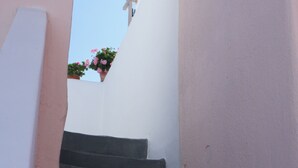 Una escalera que lleva a un edificio blanco, con un cielo despejado.