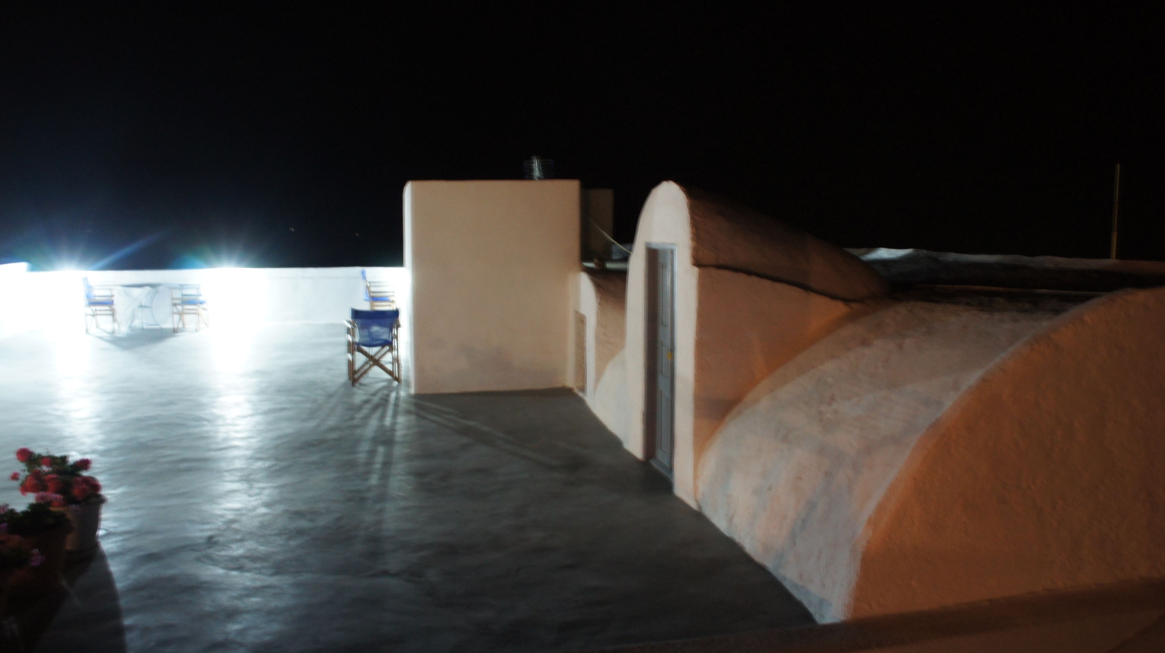 A room with a white wall, a blue chair, and a white table with a white tablecloth.