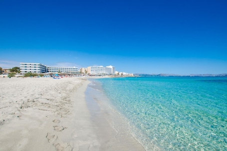 Una playa cerca, arena blanca, sillas reclinables de playa