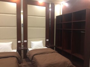 A hotel room with two beds, a wardrobe, and a mirror. - Grand Palace Hotel (Cairo)