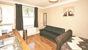 A compact living space with a kitchenette, a sofa, and a dining area. - Central Studios Gloucester Road by Rooms Booked - Free Parking (Cheltenham)