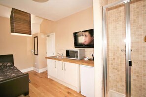 A compact kitchen with a microwave, sink, and cabinets. -  Central Studios Gloucester Road by Rooms Booked - Free Parking (Cheltenham)