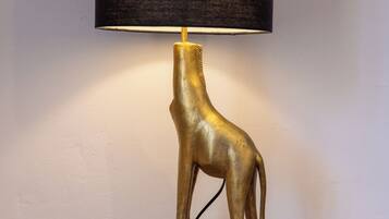 A lamp with a giraffe-shaped base and a black lampshade.