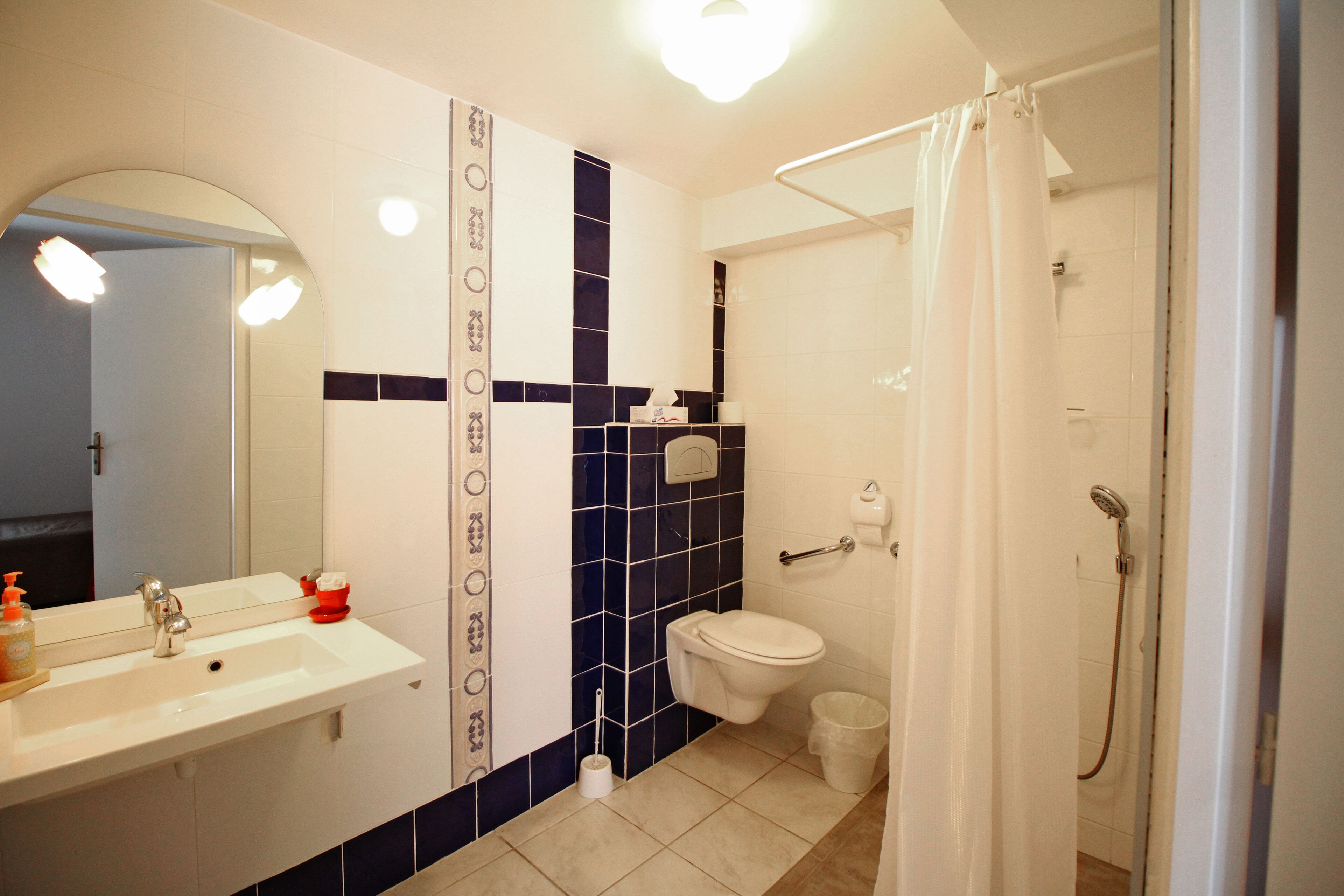 A bathroom with a sink, toilet, and shower.