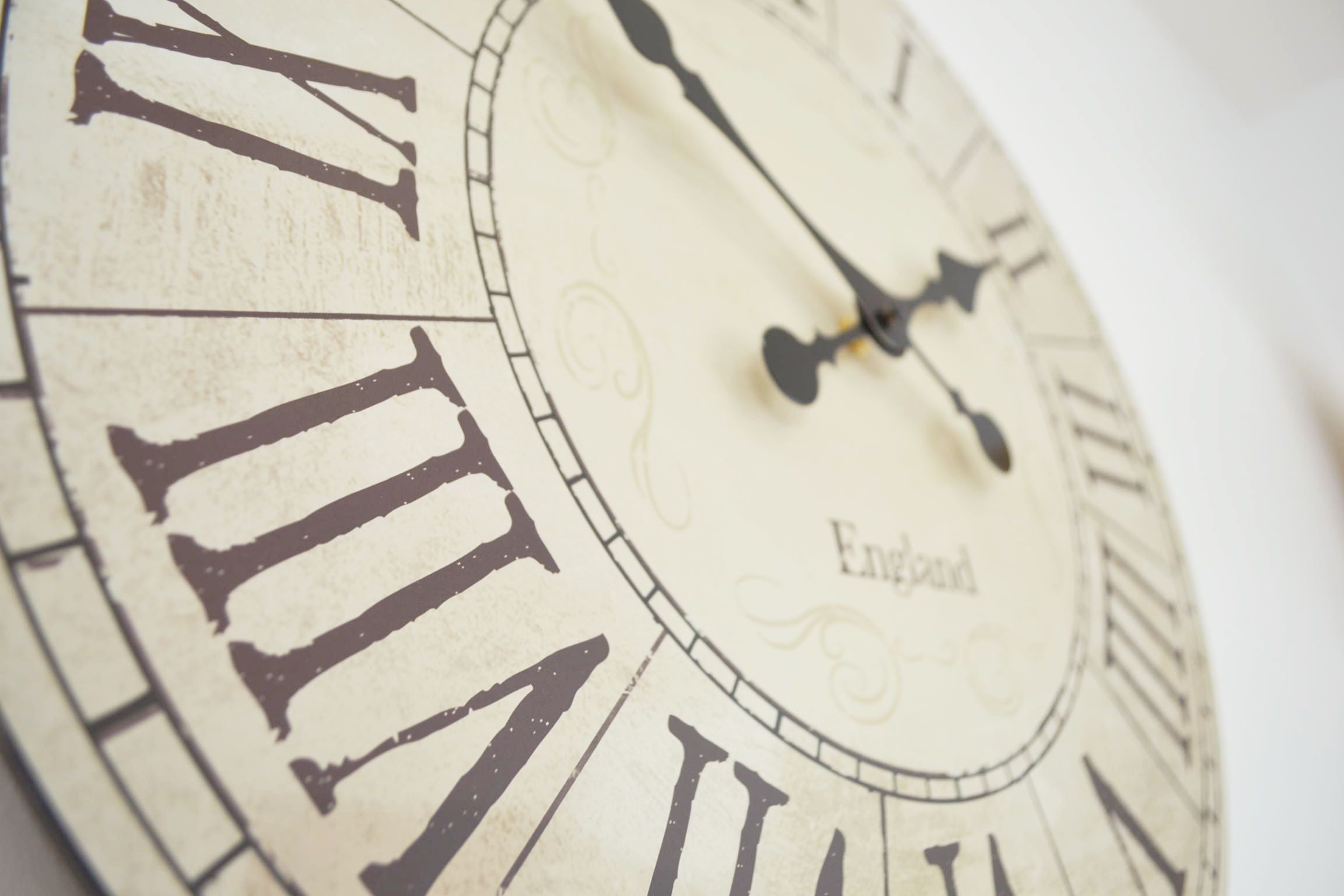 A close-up of a clock with Roman numerals and the word "England" on its face.