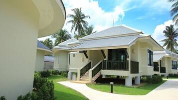 A modern two-story house with a covered porch, a staircase, and a well-maintained lawn.