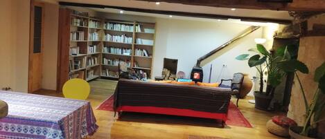 A cozy living room with a sofa, a table, and a bookshelf filled with books.