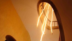 Un escalier en colimaçon avec des rampes en bois et un luminaire.