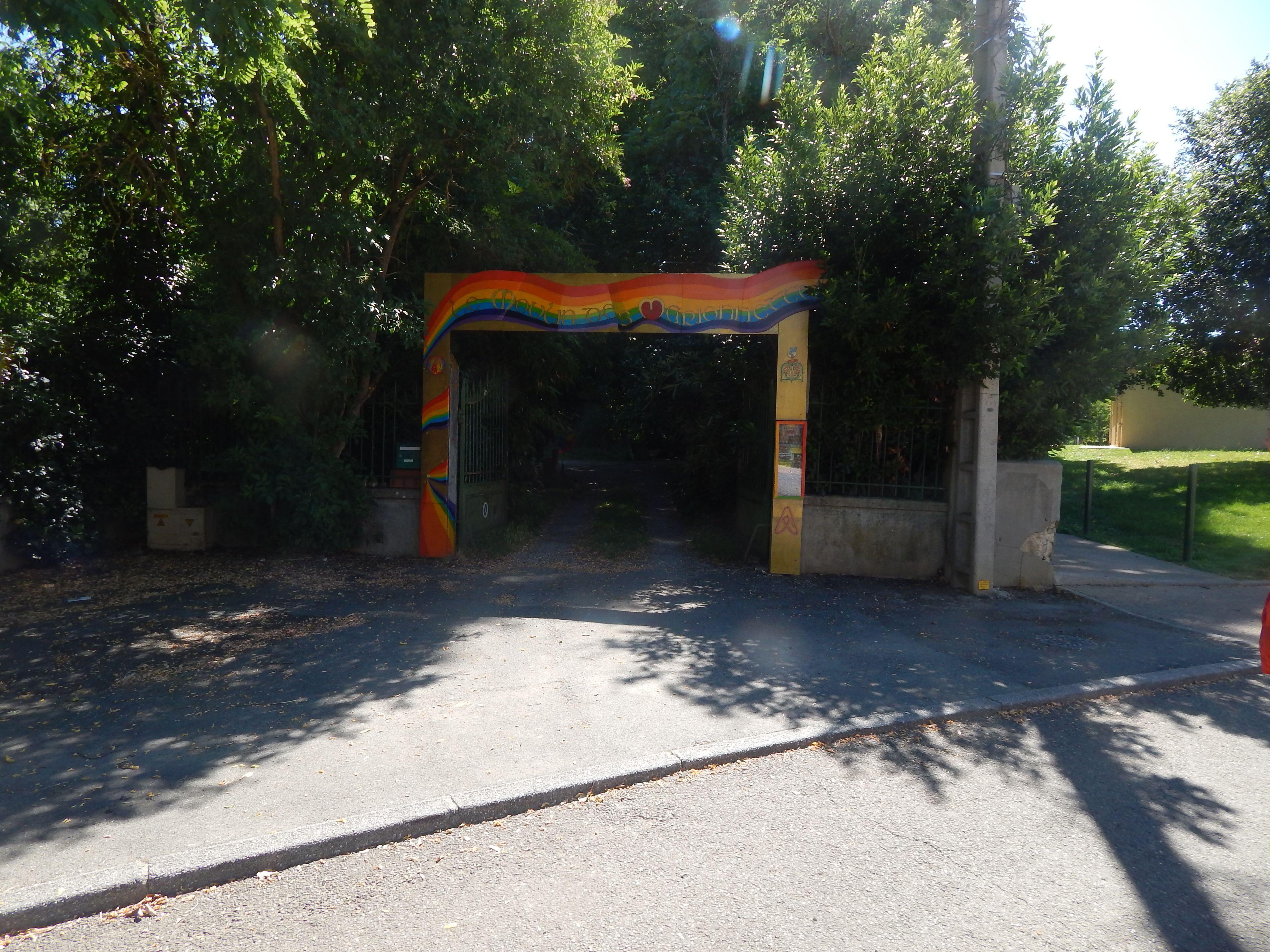 A colorful archway at the entrance of a building surrounded by trees.