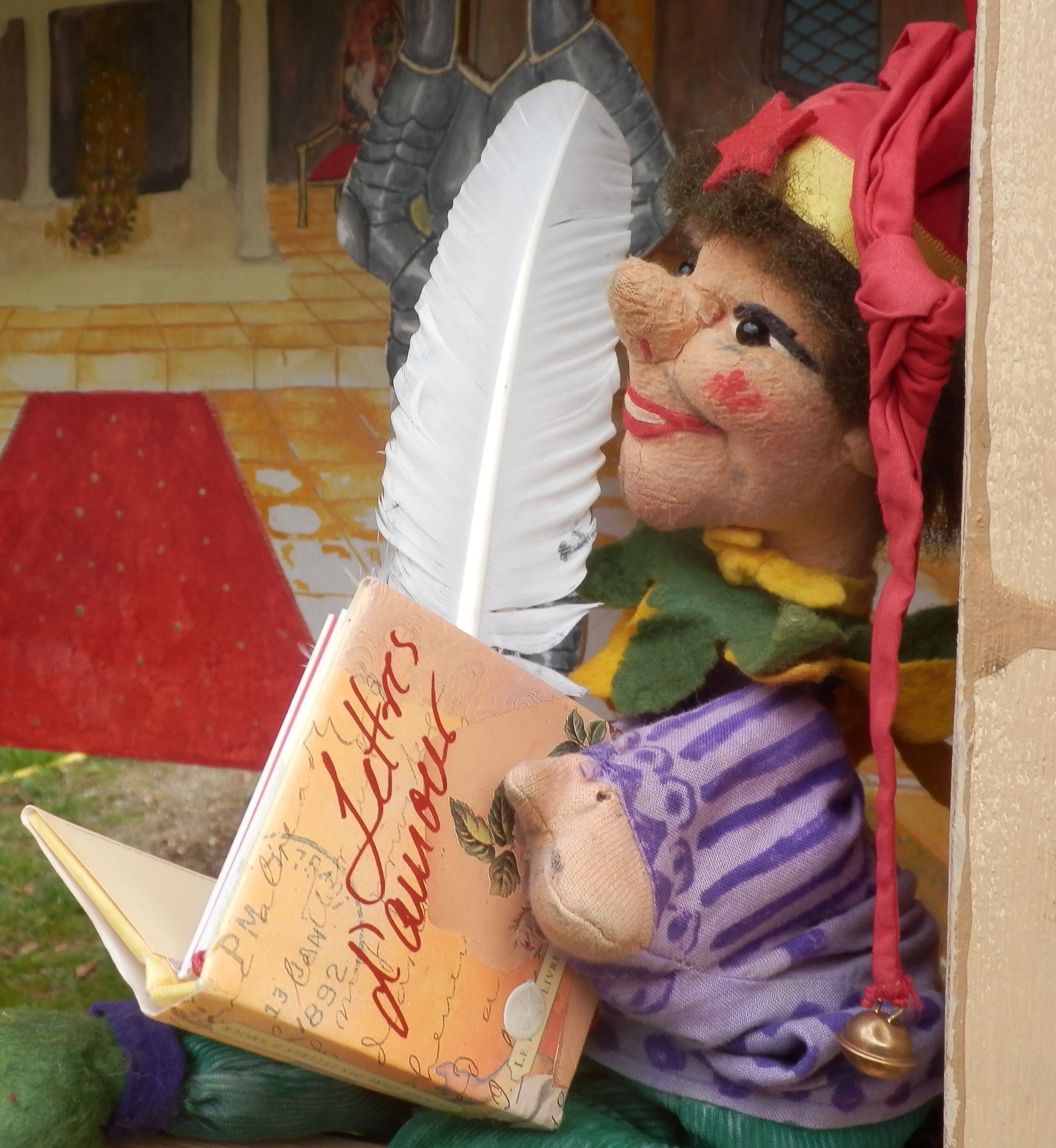 A plush toy reading a book titled "I Have a Little Book About Animals."