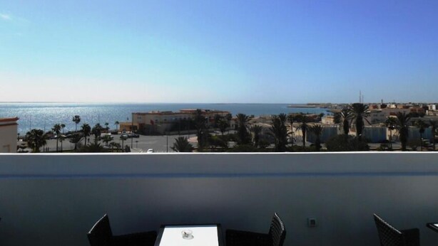 A balcony with a view of the sea and buildings. - Boutique Hôtel Albaraka (Dakhla)
