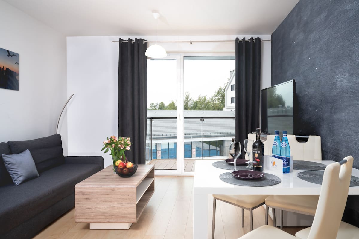 Un salon moderne avec un canapé, une table basse et un coin repas.