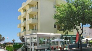 Hotel de diversos pisos amb un disseny modern, amb balcons i una zona d'estar a l'aire lliure coberta.