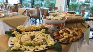 Taula de buffet amb diferents aliments, com fruita, formatge i pa.