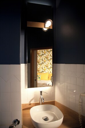 A bathroom with a white sink, wooden countertop, and a mirror above it. - Hotel Montecarlo (Riccione)