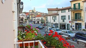 A street view with buildings, parked cars, and a pharmacy. - La Maison (Vallata)