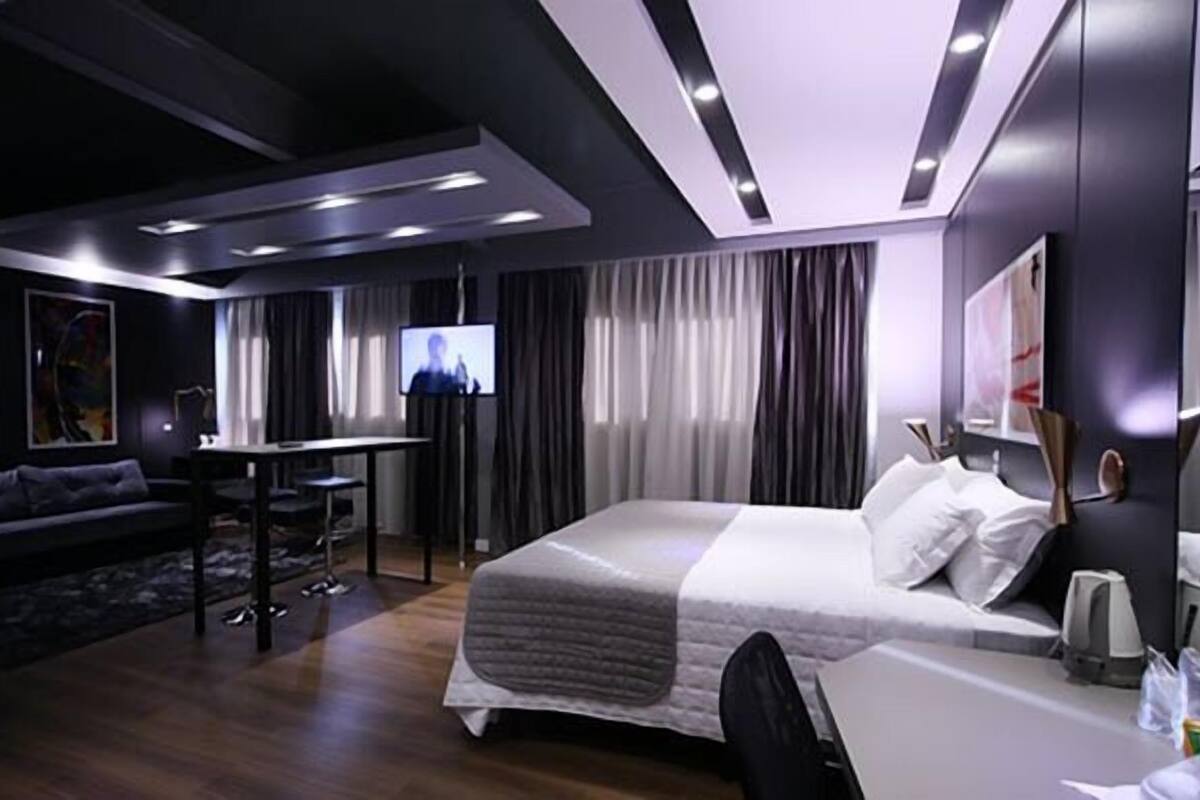 Une chambre d’hôtel moderne équipée d’un grand lit, d’un bureau, d’un canapé et d’une télévision.